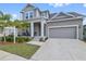 Charming two-story home with a covered porch, well-manicured lawn, and attached garage at 1432 Gopher Loop, Tarpon Springs, FL 34689