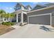 Charming two-story home with a well-manicured lawn, two-car garage, and welcoming front porch at 1432 Gopher Loop, Tarpon Springs, FL 34689