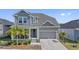 Charming two-story home with a two car garage, inviting front porch, and lush landscaping at 1432 Gopher Loop, Tarpon Springs, FL 34689
