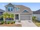 Charming two-story home with a two car garage, inviting front porch, and lush landscaping at 1432 Gopher Loop, Tarpon Springs, FL 34689