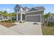 Beautiful two-story home with a two-car garage, front porch, and lush landscaping at 1432 Gopher Loop, Tarpon Springs, FL 34689