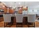 A kitchen island features dark wood and granite countertops with elegant pendant lighting above and stylish barstool seating at 1432 Gopher Loop, Tarpon Springs, FL 34689