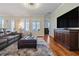 Spacious living room with hardwood floors, plush seating, and large windows at 1432 Gopher Loop, Tarpon Springs, FL 34689
