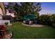 Serene backyard featuring a manicured lawn, patio seating area, and lush tropical landscaping for privacy at 14702 Dartmoor Ln, Tampa, FL 33624