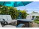 Inviting backyard patio featuring comfortable seating, a fire pit, and tropical landscaping, perfect for outdoor relaxation at 14702 Dartmoor Ln, Tampa, FL 33624