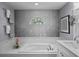 Spacious bathroom featuring a tub with an accent wall, natural light and updated fixtures at 14702 Dartmoor Ln, Tampa, FL 33624