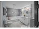 A luxurious bathroom with double vanity, modern fixtures, walk in shower, and soaking tub at 14702 Dartmoor Ln, Tampa, FL 33624