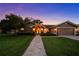 Charming home at twilight with a manicured lawn and a stone walkway leading to the front entrance at 14702 Dartmoor Ln, Tampa, FL 33624