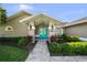 Inviting front entrance with a vibrant turquoise double door and lush landscaping at 14702 Dartmoor Ln, Tampa, FL 33624