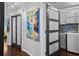 Hallway with sliding doors, artwork, and entry to the laundry room with sink and modern appliances at 14702 Dartmoor Ln, Tampa, FL 33624