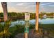 Informative lakeside signage near a serene water feature, promoting environmental awareness and responsible recreation at 14702 Dartmoor Ln, Tampa, FL 33624