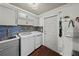 Laundry room featuring modern washer and dryer, stylish backsplash, and ample cabinet space at 14702 Dartmoor Ln, Tampa, FL 33624