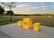 Inviting park picnic area, featuring bright yellow table & stools, set against a sprawling green field at 14702 Dartmoor Ln, Tampa, FL 33624
