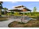 Outdoor picnic pavilion with multiple picnic tables and a double-tiered roof structure at 14702 Dartmoor Ln, Tampa, FL 33624