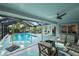 Outdoor pool featuring turquoise decking, screened enclosure, and multiple seating areas at 14702 Dartmoor Ln, Tampa, FL 33624