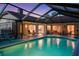 Backyard screened-in pool, offering a refreshing oasis for relaxation and entertainment, surrounded by lush landscaping at 14702 Dartmoor Ln, Tampa, FL 33624