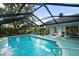 Enclosed pool area with blue water, lounge chairs, and a view of the backyard at 14702 Dartmoor Ln, Tampa, FL 33624