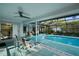 Relaxing pool area with lounge chairs, covered patio, and serene views of the backyard at 14702 Dartmoor Ln, Tampa, FL 33624