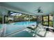 A relaxing pool area with lounge chairs, screened enclosure, and a view of the backyard at 14702 Dartmoor Ln, Tampa, FL 33624