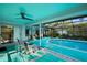 A beautiful screened in pool area with an outdoor seating and covered lounge chairs at 14702 Dartmoor Ln, Tampa, FL 33624