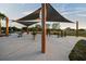 Outdoor workout area featuring various exercise machines and shaded seating under modern canopies at 14702 Dartmoor Ln, Tampa, FL 33624
