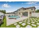 This backyard features a covered patio, private pool, stylish tile and turf combination, and white privacy fence at 14718 Rocky Brook Dr, Tampa, FL 33625