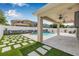 Backyard featuring a pool, seating, patio, and well-manicured artificial turf at 14718 Rocky Brook Dr, Tampa, FL 33625