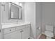 Bathroom with white vanity, modern sink, mirror, and toilet at 14718 Rocky Brook Dr, Tampa, FL 33625