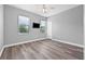 Bright bedroom featuring wood floors, neutral walls, a ceiling fan, and natural light from two windows at 14718 Rocky Brook Dr, Tampa, FL 33625