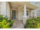 Inviting front porch with classic columns, brick pavers, and lush landscaping creates a welcoming entrance at 14718 Rocky Brook Dr, Tampa, FL 33625