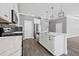 Modern kitchen features white cabinets, stainless steel appliances, marble countertops, and stylish pendant lighting at 14718 Rocky Brook Dr, Tampa, FL 33625