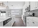 Modern kitchen features white cabinets, stainless steel appliances, marble countertops, and stylish pendant lighting at 14718 Rocky Brook Dr, Tampa, FL 33625