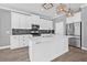 Modern kitchen features white cabinets, stainless steel appliances, marble countertops, and stylish pendant lighting at 14718 Rocky Brook Dr, Tampa, FL 33625