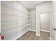 Walk-in pantry offers ample storage space with multiple wire shelves and durable wood-look tile flooring at 14718 Rocky Brook Dr, Tampa, FL 33625