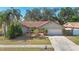 Well-maintained single-Gathering home with mature trees and landscaping on a sunny day at 1623 Carter Oaks Dr, Valrico, FL 33596