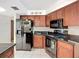 Kitchen featuring black appliances, cherry wood cabinets, and tile flooring at 1623 Carter Oaks Dr, Valrico, FL 33596