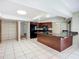 Spacious kitchen featuring a large island, wooden cabinets, and tile flooring at 1623 Carter Oaks Dr, Valrico, FL 33596