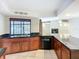 Cherry wood kitchen with black appliances and countertops overlooks a pool area at 1623 Carter Oaks Dr, Valrico, FL 33596
