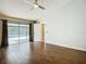 Open main bedroom with wood floor, fan, and sliding glass doors leading to pool area at 1623 Carter Oaks Dr, Valrico, FL 33596