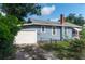 Exterior view of home featuring a one car garage, brick chimney and chain link fence at 1716 11Th N Ave, St Petersburg, FL 33713