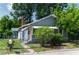 Charming bungalow with a red brick chimney, red door, and a fenced yard on a sunny day at 1716 11Th N Ave, St Petersburg, FL 33713
