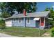 Street view of the blue house with a red door, showcasing curb appeal and a well-kept lawn at 1716 11Th N Ave, St Petersburg, FL 33713