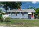 Exterior view of home showing blue siding, chimney and a red front door at 1716 11Th N Ave, St Petersburg, FL 33713