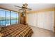Bright bedroom with ceiling fan, ample closet space, and water views from sliding glass doors to the lanai at 19111 Vista Bay Dr # 603, Indian Shores, FL 33785