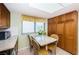 Sunlit kitchen dining area featuring a granite table, oak cabinets, and a view through a window at 19111 Vista Bay Dr # 603, Indian Shores, FL 33785