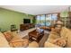 Bright living room features stylish furnishings, tile flooring, and sliding glass doors to the lanai with water views at 19111 Vista Bay Dr # 603, Indian Shores, FL 33785