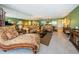 Spacious living room with mirrored wall, comfortable seating, and access to dining area at 19111 Vista Bay Dr # 603, Indian Shores, FL 33785