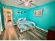 Bright bedroom with teal walls, a ceiling fan, and wood-look flooring at 2020 World Parkway Blvd # 14, Clearwater, FL 33763