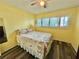 Bedroom featuring yellow walls, hardwood floors, ceiling fan and a window with shutters at 2020 World Parkway Blvd # 14, Clearwater, FL 33763
