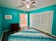 Bedroom with teal walls, built-in closet, ceiling fan, and laminate floors at 2020 World Parkway Blvd # 14, Clearwater, FL 33763